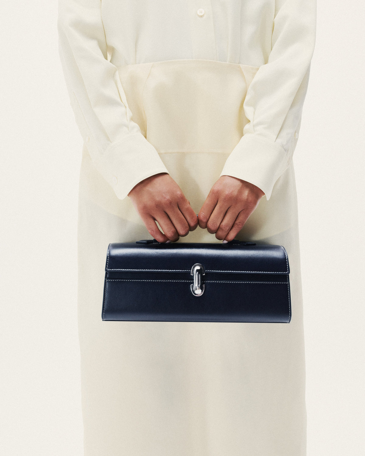 on model image of a navy blue bag with a silver clasp