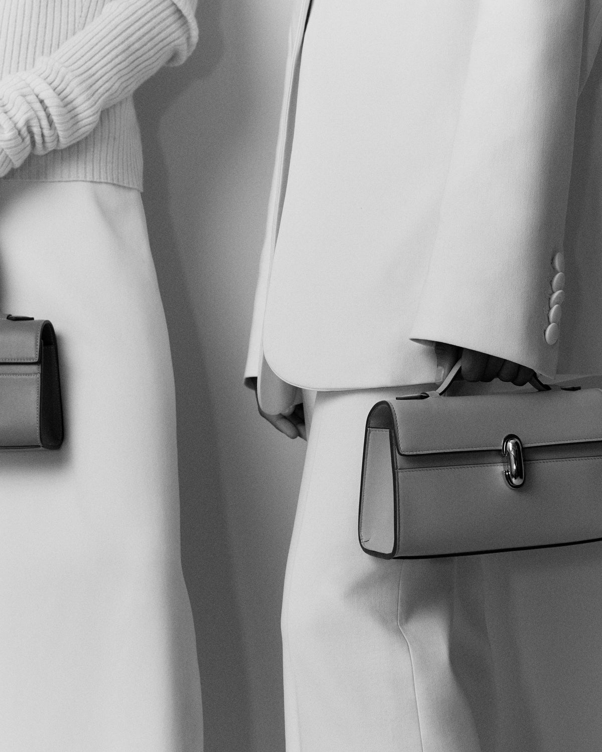 Two women carrying Symmetry Pochette handbags